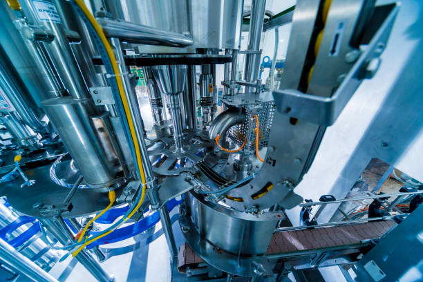 istock Automatic filling machine pours water into plastic PET bottles. Brewing production. 1184898867