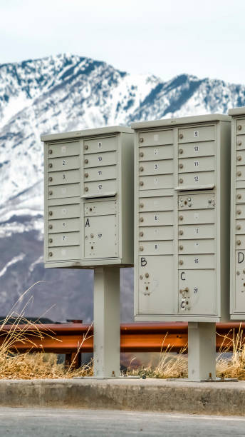 istock Vertical frame Mailboxes with compartments and numbers against snowy mountain and cloudy sky 1184899978
