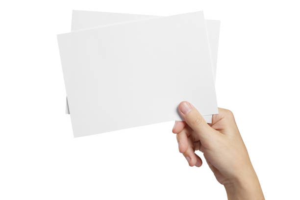 istock Hand holding two small sheets of paper on white 1184906688
