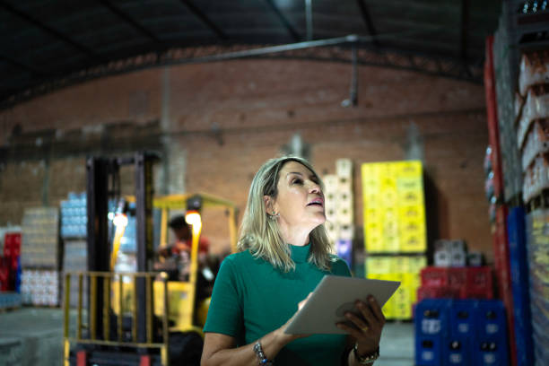 istock Employee looking at products and using digital tablet at warehouse 1184907118