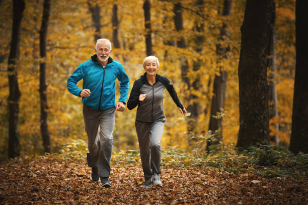숲에서 조깅하는 선배 부부. - running cheerful outdoors senior couple 뉴스 사진 이미지