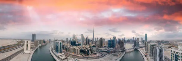 Panoramic aerial view of Dubai skyline from helicopter at sunset, United Arab Emirates.