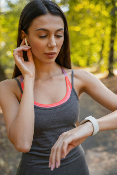 istock Pretty woman fixing her wristwatch before jogging 1184912328