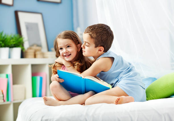istock Children reading book in bed 1184913747