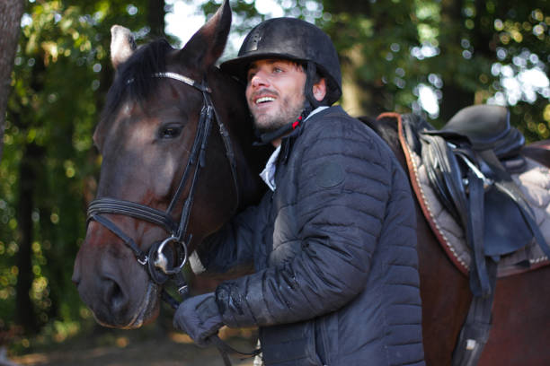 istock Young man stroking a brown horse 1184913794