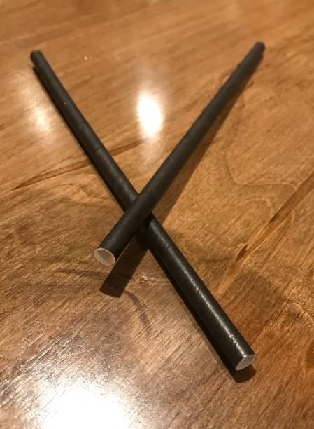 istock Black Paper straw on wood table, non plastic 1184916580