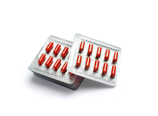 istock Red pill capsules in blister packs on white background 1184918474
