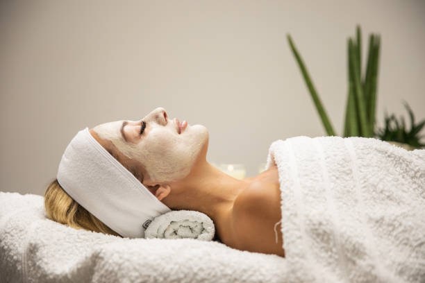 Beautiful woman with mask on face in spa beauty salon stock photo