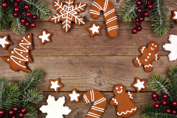 istock Christmas frame of gingerbread cookies and tree branches, top view on a rustic wood background 1184922466