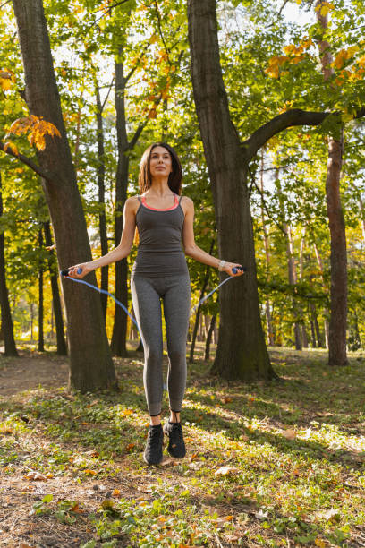 istock Concentrated sportswoman skipping during training in the park 1184923505