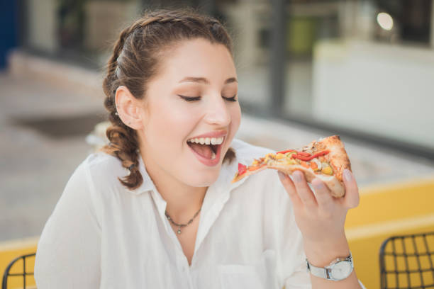 istock Beautiful woman eating pizza 1184925337