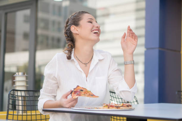 istock Beautiful woman eating pizza 1184925470