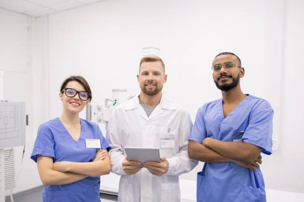 istock Group of three young successful intercultural clinicians or interns in uniform 1184925765