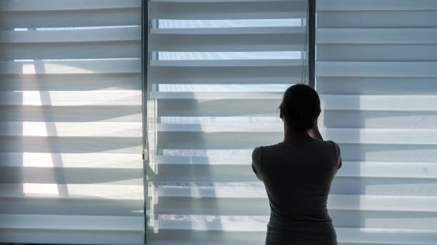 istock Woman is opening blinds 1184927202