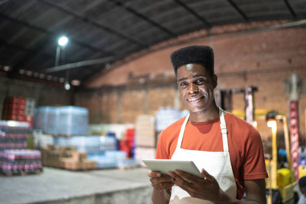 istock Portrait of smiling employee using digital tablet at warehouse 1184930047