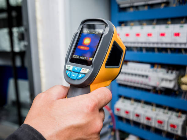 istock Technician use infrared thermal imaging camera to check temperature at fuse-box 1184930179