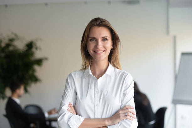 bras restants de gestionnaire féminin de sourire s'amonsurait regardant l'appareil-photo - business women manager looking at camera photos et images de collection