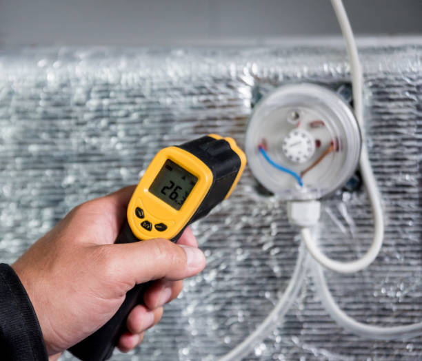 istock Technician use infrared thermal imaging camera to check temperature at fuse-box 1184933064
