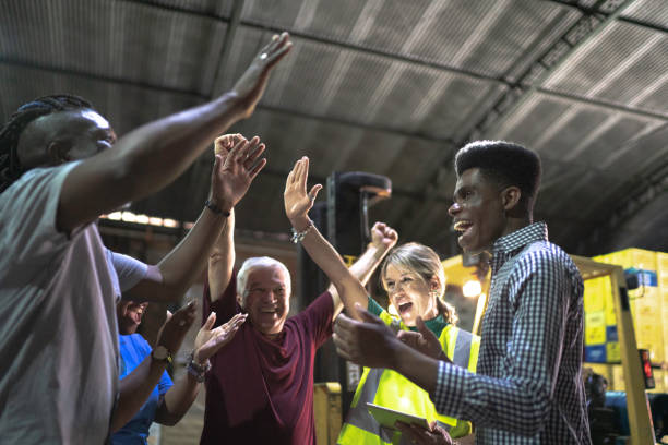 istock Happy employees celebrating together at warehouse 1184933201