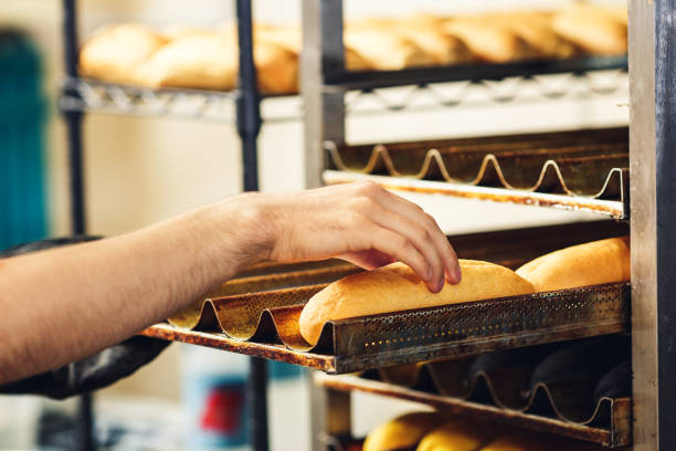 istock baker puts hot dog buns on pallets. 1184935417
