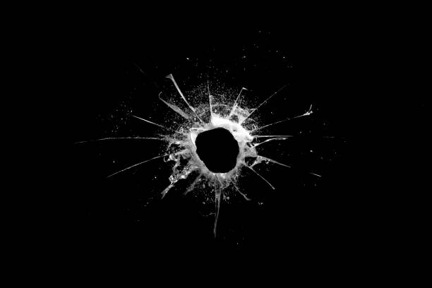 istock hole in the glass with cracks isolated on a black background 1184935600
