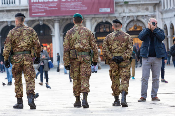 military patrol walking near photographer in piazza san marco in venice - tourist photographing armed forces military imagens e fotografias de stock