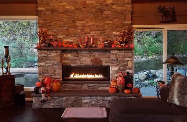 Rustic Stone Fireplace, Flames Glowing, During the Daytime of the Autumn Holiday Season stock photo
