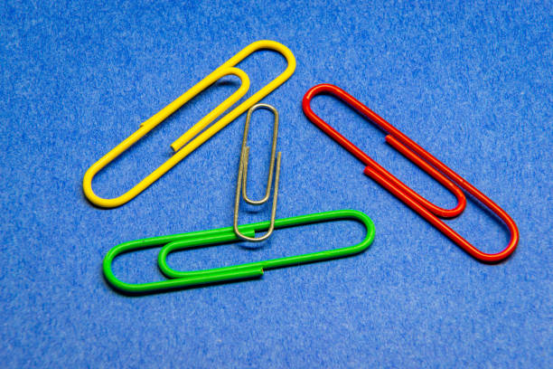 A paper clip (or sometimes paperclip) is a device used to hold sheets of paper together, usually made of steel wire bent to a looped shape (though some are covered in plastic)