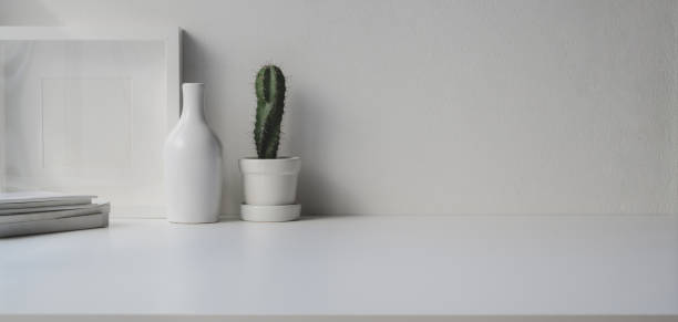 istock Minimal office room with copy space and decorations on white wooden table 1184955978