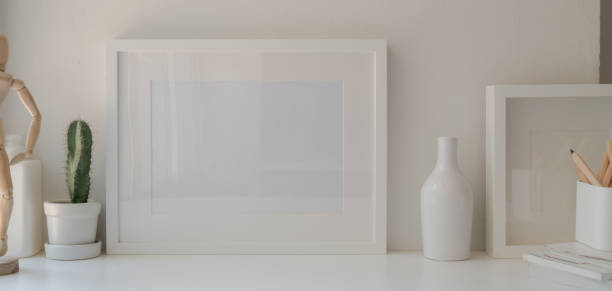 istock Minimal office room with mock up frame and decorations on white wooden table and white wall 1184956006