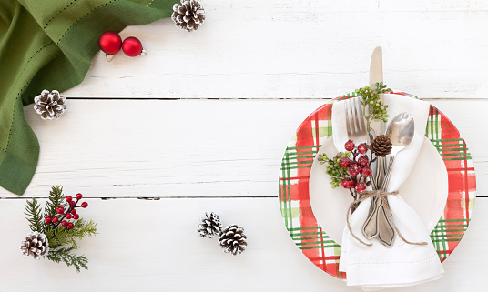 Holiday Christmas dining place setting on an old white wood background
