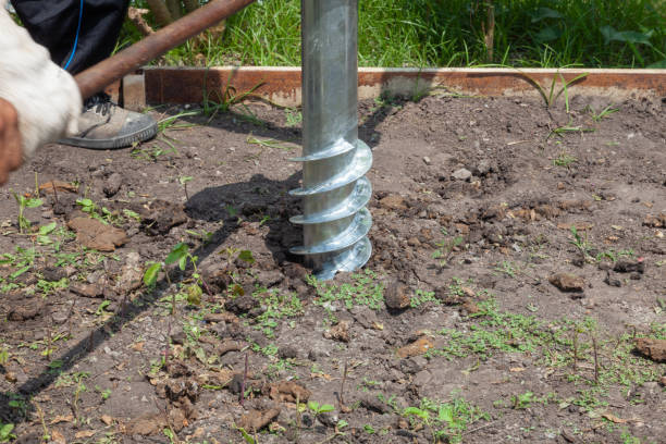 istock Worker manual drilling hole on the ground at sunny day 1184958574