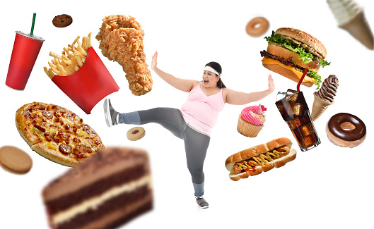 Overweight Asian woman fighting off junk food isolated on white background