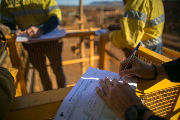 safety supervisor checking and reviewing document before issued sigh of working at height permit - meeting community manager business imagens e fotografias de stock