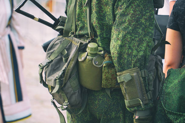 a flask and various ammunition on a belt at the soldier - military canteen imagens e fotografias de stock