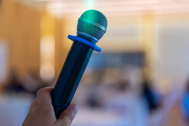 istock close up wireless mic in the seminar classroom with blur students behind 1184973925