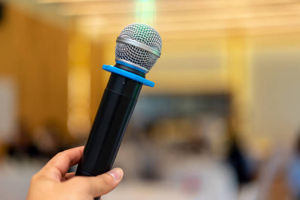 istock close up wireless mic in the seminar classroom with blur students behind 1184973990