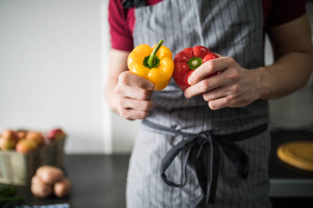 istock Man throwing pepper into air. guy preparing food at kitchen counter 1184977047