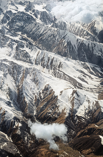 Aerial view of a snowy mountain range. The concept of uniqueness and diversity of nature. Natural background. Flight over Georgia. Vertical photo