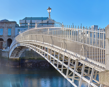 Half penny bridge, also called Ha'penny bridge,on a bridht day under blue sky in Dublin, Republic of Ireland,