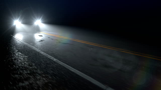 Car drives along country night wet road with headlights turned on, seamless loop