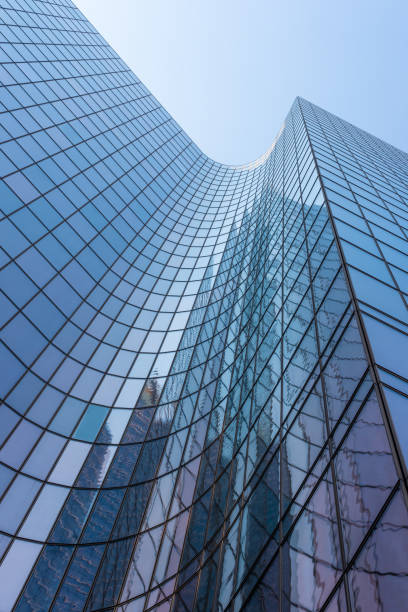 Blue glass skyscraper facade against sky stock photo