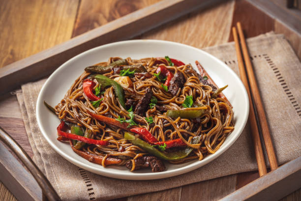 fideos soba con verduras y carne de res, cocina de estilo asiático. - chopsticks stir fried vegetable beef fotografías e imágenes de stock