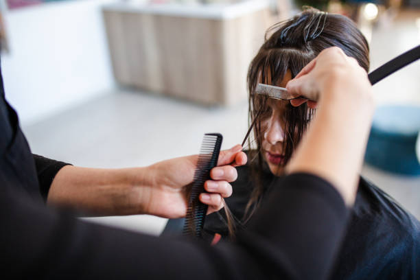 Client having bangs trimmed during haircut Young female Client having bangs trimmed during haircut by professional hairdresser bangs stock pictures, royalty-free photos & images