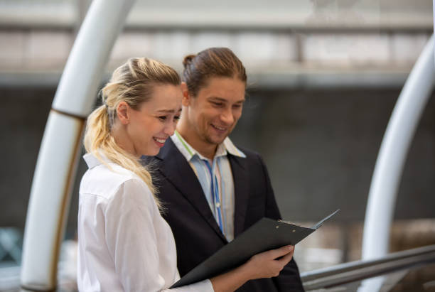 istock Happy Business Colleagues Discussing Document While Standing In Office 1184996461
