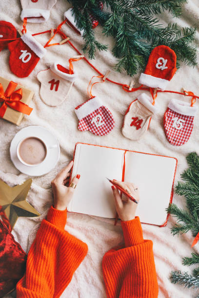 istock Woman writing in a blank notebook - Christmas concept flat lay 1184998595