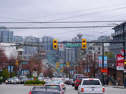 Vancouver, Canada, March 2018: Dense city traffic moves along asphalt highway leading through the grey streets of Vancouver. Cars and pick up trucks drive past a Wendy's restaurant in Canadian city.