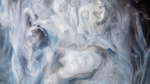 istock Abstract bronze paint mixed with different multi-colored paints in water in slow motion. Inky cloud swirling flowing underwater. Abstract smoke explosion 1185003467
