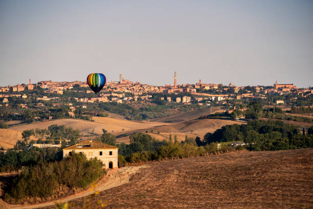 панорама сиены на рассвете с воздушным шаром - torre del mangia стоковые фото и изображения