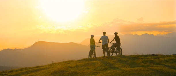 istock Three young cyclists rest at the mountain top before riding downhill at sunset. 1185006103